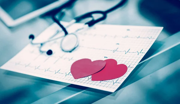 Gezondheidsconcept: twee rode papieren hart op het elektrocardiogram, t — Stockfoto