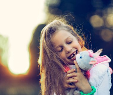 sevimli küçük kız bir favori doldurulmuş hayvan - bir kedi için sarılma