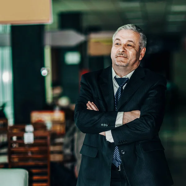 Portrait of a successful businessman on background of modern off — Stock Photo, Image