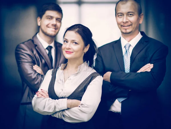 Усміхнені співробітники стоять один за одним в офісі — стокове фото