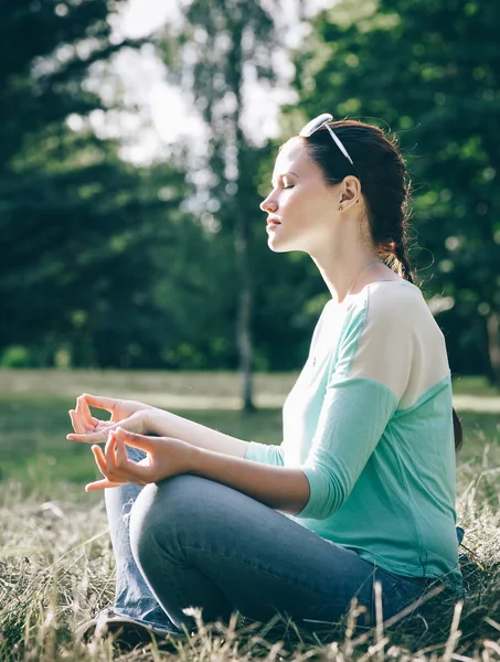 Seitenansicht. Schöne Frau meditiert im Freien in Lotusposition — Stockfoto