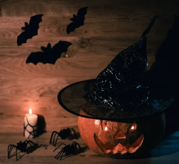Strašidelná dýně na Halloween v čarodějnice klobouk na dřevěném pozadí — Stock fotografie