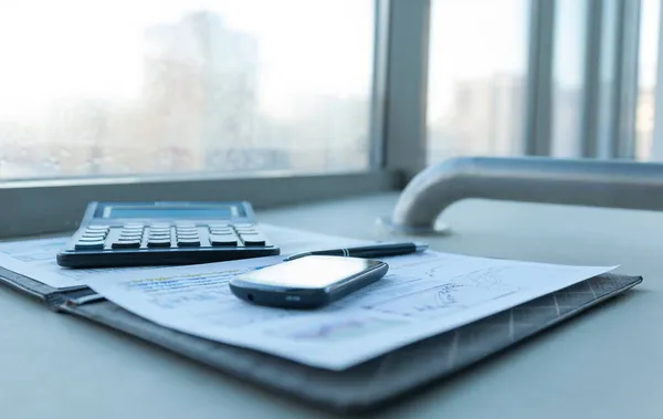 Taschenrechner, Smartphone und Finanzdokumente im Geschäft — Stockfoto