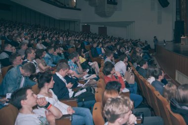 Yan görüş. Bir iş konferansı sırasında konferans odasında oturan seyirci.