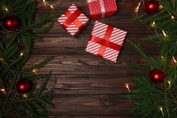 Geschenkdozen en dennentakken op een houten ondergrond. — Stockfoto
