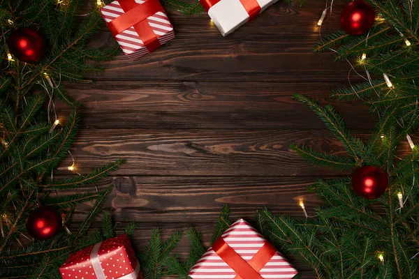 Scatole regalo e rami di abete su uno sfondo di legno. — Foto Stock