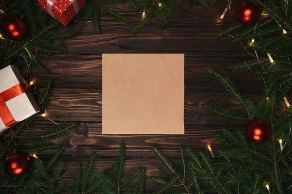 Folha de papel artesanal e um presente em um quadro de grinalda de Natal . — Fotografia de Stock
