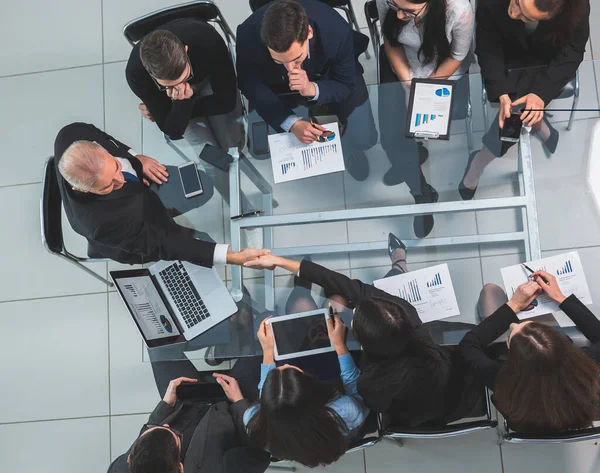 Vista dall'alto. stretta di mano dei partner finanziari ad una riunione di lavoro. — Foto Stock