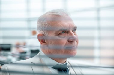 Kapat. Neşeli ofis çalışanı pencere perdelerinden bakıyor..