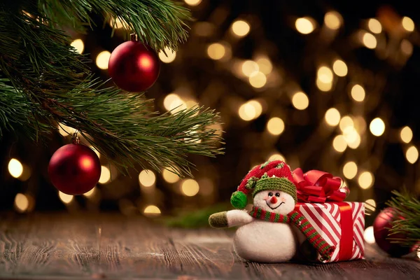 Allegro pupazzo di neve e scatole con regali di Natale su uno sfondo festivo. — Foto Stock