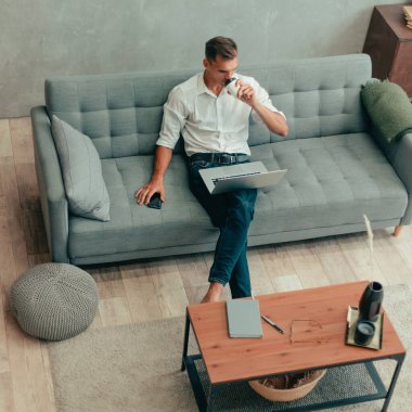 Genç adam rahat bir oturma odasında dinleniyor..