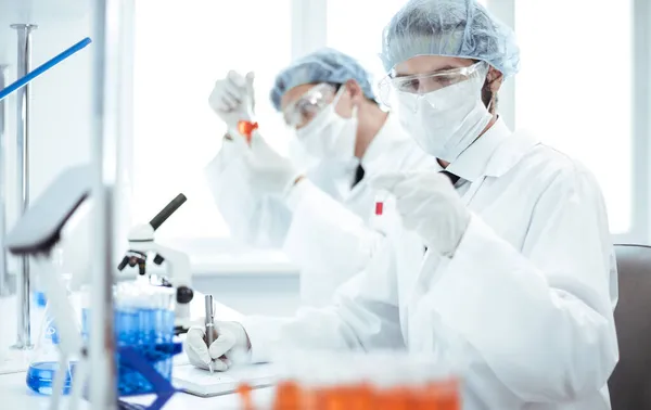 På nära håll. grupp av laboratorietekniker utför tester i laboratoriet . — Stockfoto