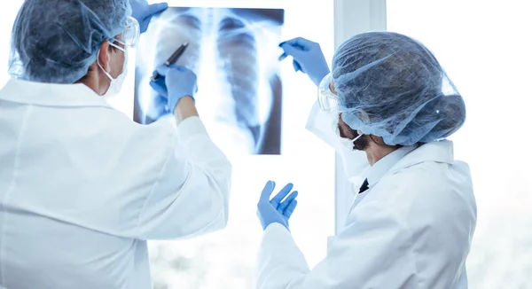 Nahaufnahme. Ärztekollegen diskutieren über eine Röntgenaufnahme der Lunge . — Stockfoto