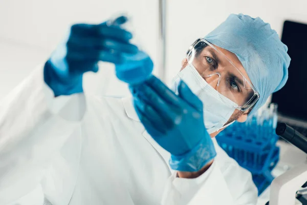 Frasco com os resultados da experiência nas mãos de um cientista . — Fotografia de Stock