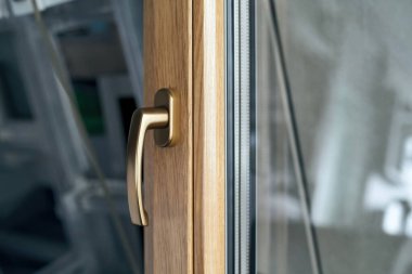 Pencere çerçevesinde altın renginde şık tutuş.