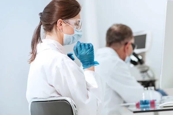 Fecha. cientista feminina sentada em uma mesa de laboratório. — Fotografia de Stock
