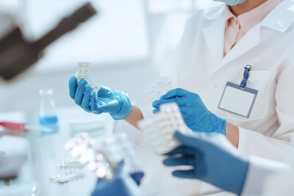 Vědci se vzorky nových léků sedí u laboratorního stolu. Royalty Free Stock Obrázky