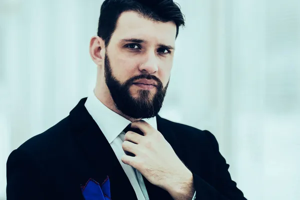 Successful businessman adjusting his necktie while standing near — Stock Photo, Image