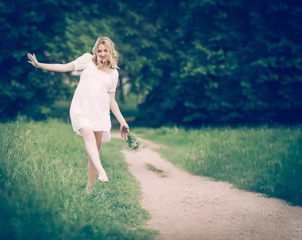 Schwangere, die im Park barfuß auf Teppich geht, h — Stockfoto