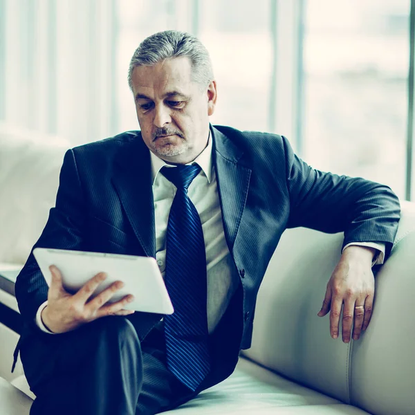 Hombre de negocios experimentado mirando la pantalla de una mesa digital — Foto de Stock