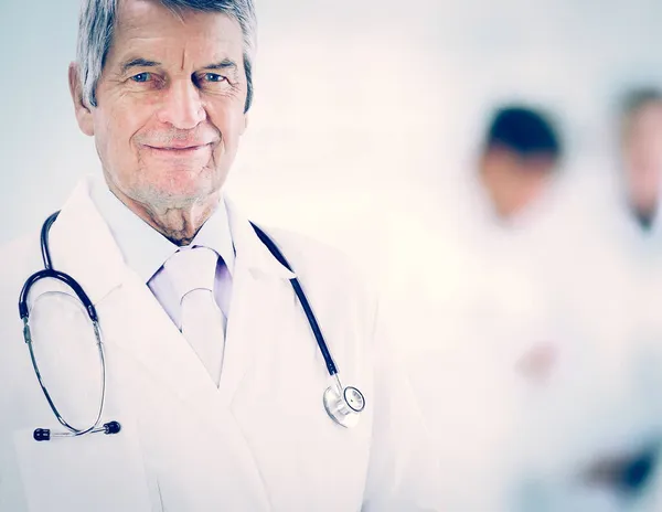 Retrato de un médico experimentado en edad, en el trabajo de fondo — Foto de Stock