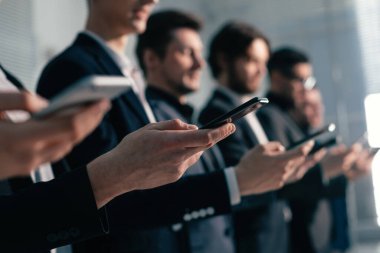 Genç iş adamları akıllı telefon ekranlarına yakından bakıyor