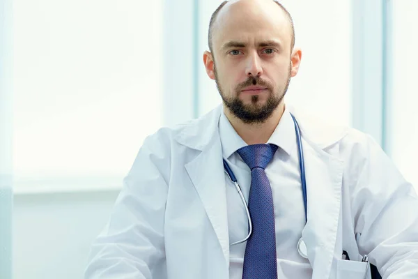 Gros plan. médecin sérieux assis à son bureau. — Photo