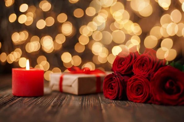 Boxes with gifts and a bouquet of flowers on the background of festive lights . — Stock Photo, Image