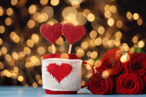 Decorative cup with valentines and a bouquet of roses on a festive background. — Stock Photo, Image