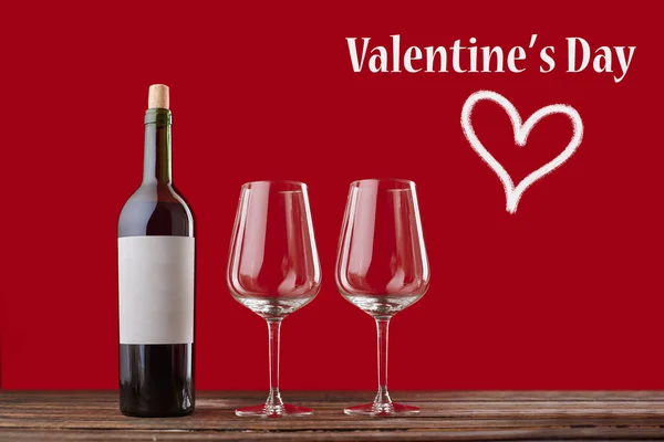 Láhev červeného vína a dvě sklenice vína na slavnostním pozadí. Stock Obrázky