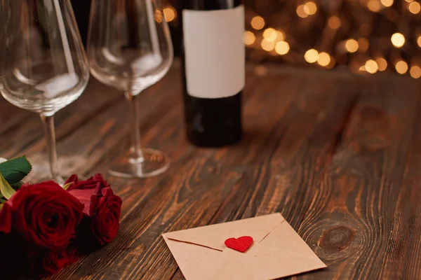 Конверт з валентиною і букет з троянд на дерев'яному столі . Ліцензійні Стокові Зображення