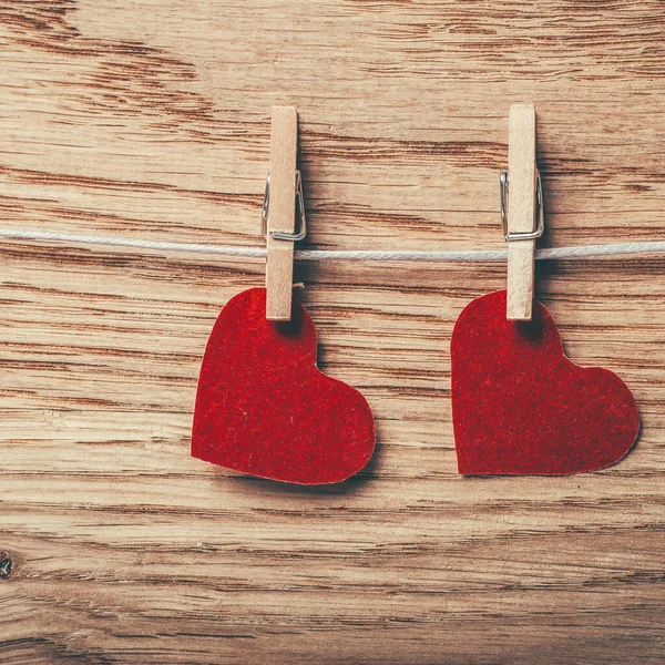 Dois corações vermelhos em clothspins no fundo de madeira — Fotografia de Stock