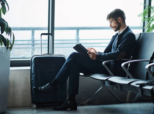 Man using a digital tablet in the departure hall of the airport. — Stock Photo, Image