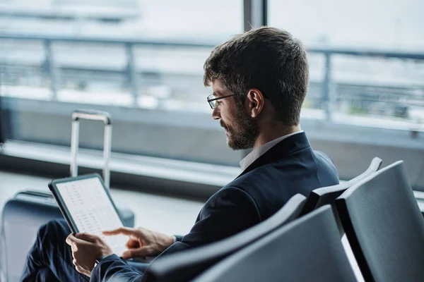 Homme d'affaires travaille sur une tablette numérique, assis sur un banc dans le — Photo