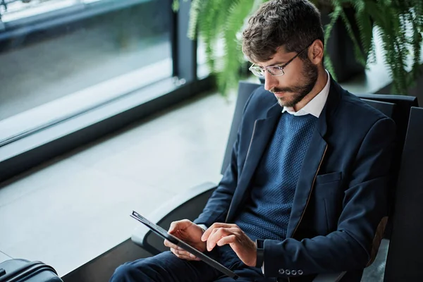 Empresário com um tablet digital sentado na sala de espera . — Fotografia de Stock