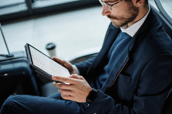 Businessman works on a digital tablet while waiting for his flight . close-up. — Stock Photo, Image