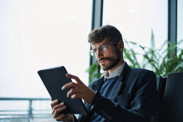 Business man thoughtfully looking at the screen of a digital tab — Stock Photo, Image