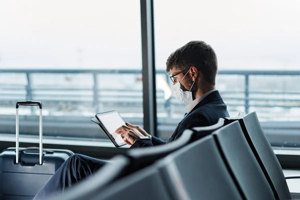 Passager de l'aéroport utilisant une tablette numérique en attendant son f — Photo