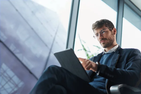 Homem de negócios usando seu computador tablet durante uma viagem. — Fotografia de Stock