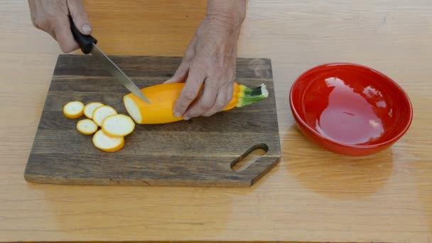 Las manos de la abuela cortan el calabacín — Vídeo de stock