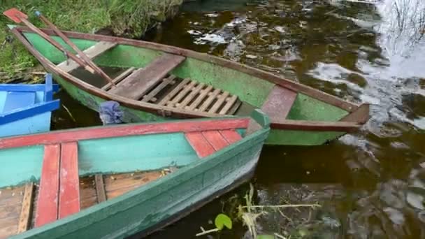 Oude houten boten op meerwater — Stockvideo