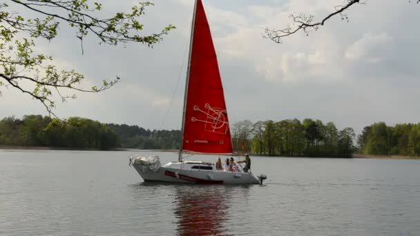 Yate con vela roja en el lago — Vídeo de stock