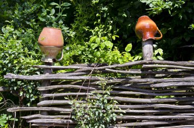 Wicker fence with clay jugs clipart