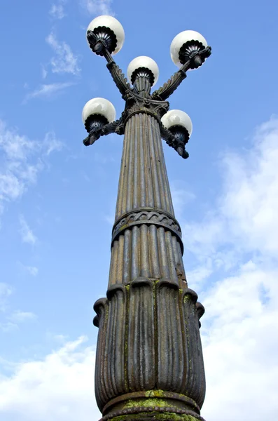Древняя уличная лампа на фоне неба — стоковое фото
