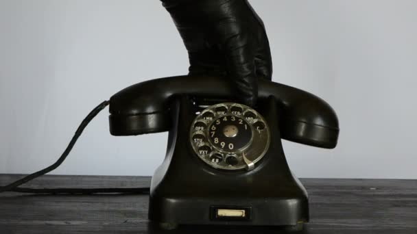 Mano con guante negro llamando con teléfono vintage — Vídeos de Stock