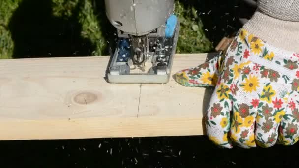 Carpenter cutting wooden board with electric saw — Stock Video