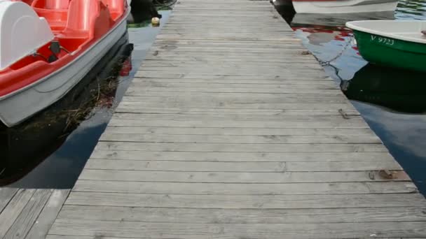 Wooden bridge on lake and boats — Stock Video