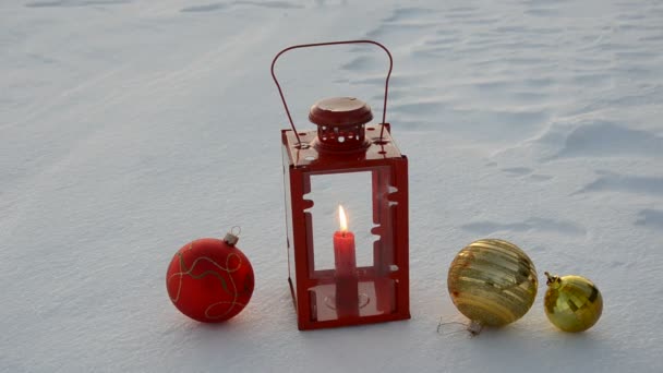 Kerstballen en lamp met kaars op sneeuw — Stockvideo
