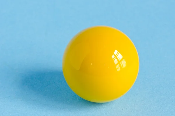 One yellow billiards ball on azure background — Stock Photo, Image