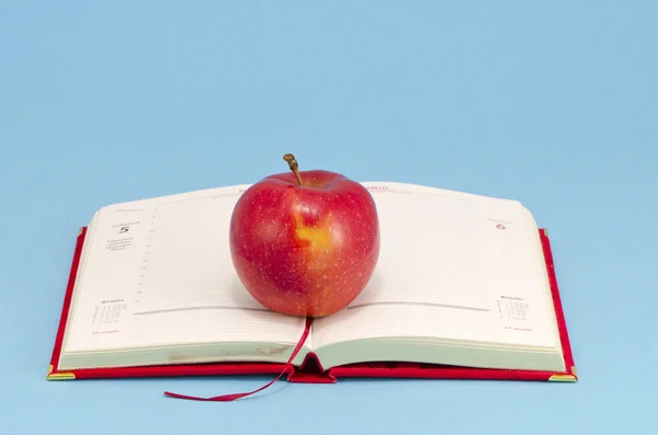 Förgyllda businees kalender med rött äpple — Stockfoto